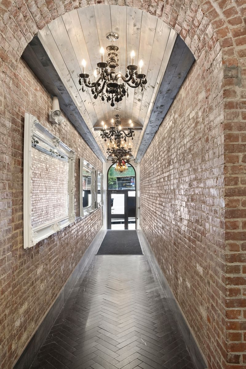 a view of a hallway with wooden floor and a chandelier
