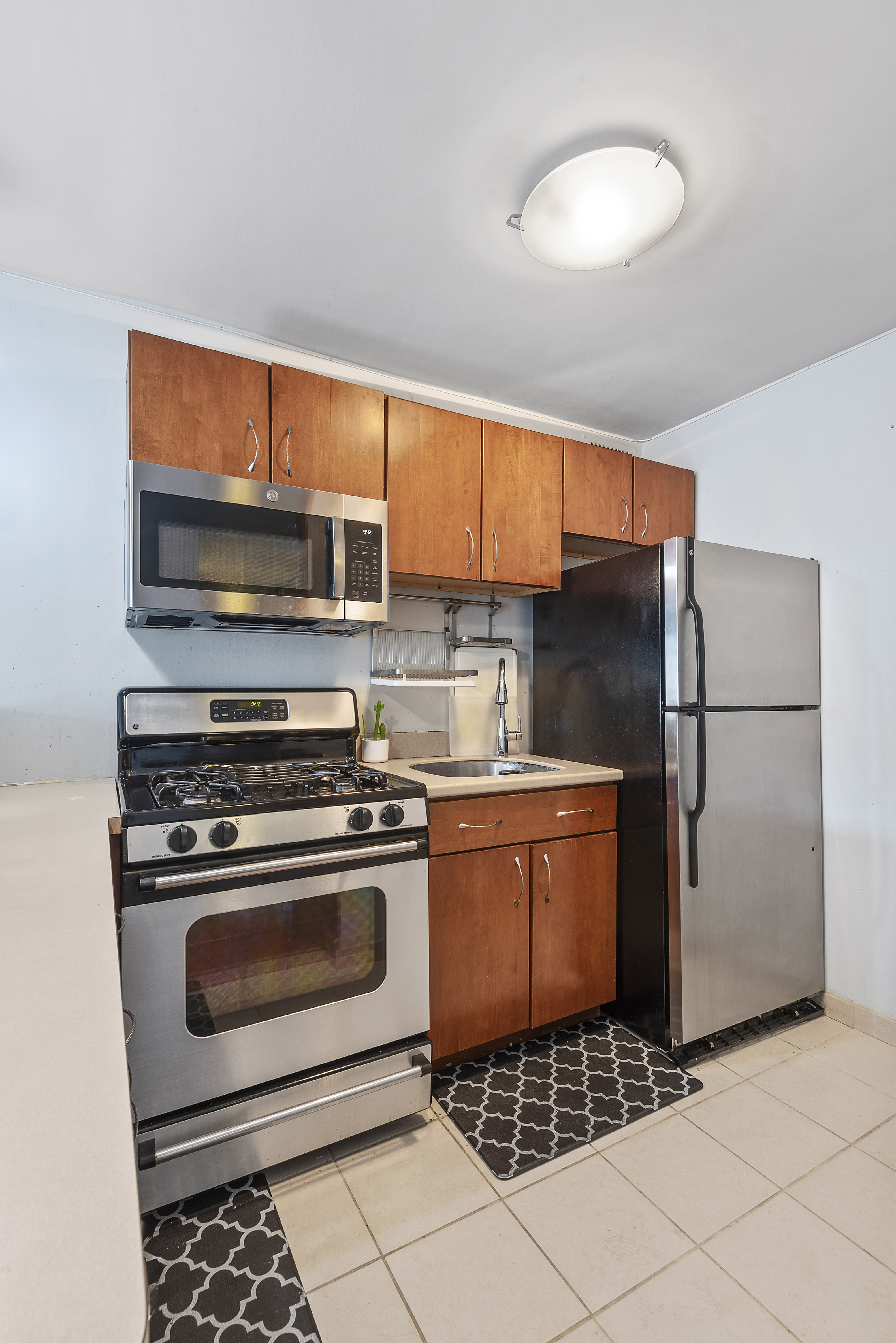 195 Willoughby Avenue, Unit 1411 Brooklyn, NY 11205 - Photo 3 of 6 a kitchen with a stove a refrigerator and a microwave