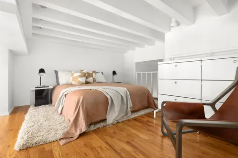 a bedroom with bed and wooden floor