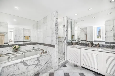 a bathroom with a granite countertop sink mirror and a bathtub