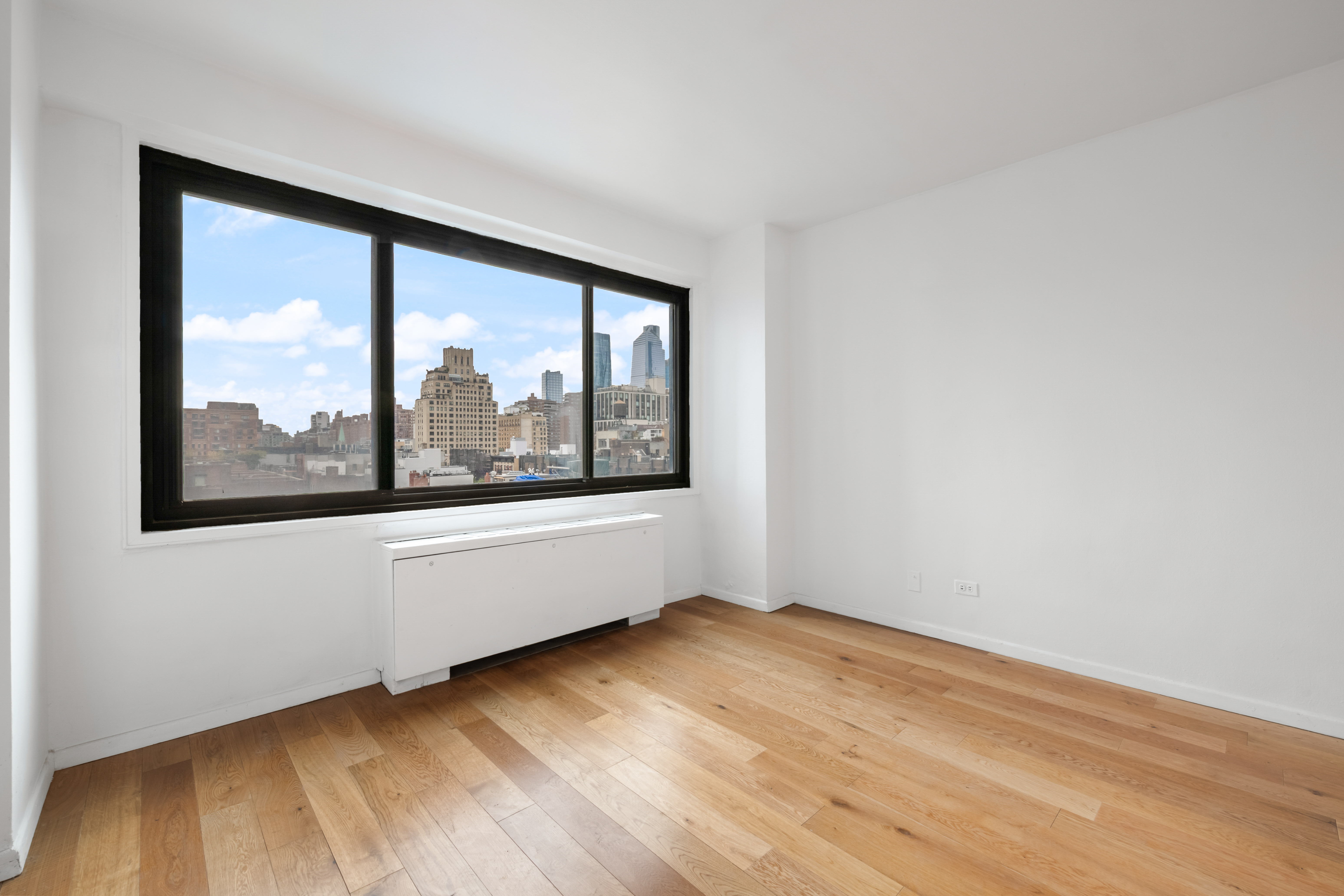 201 West 21st Street, Unit 9A Manhattan, NY 10011 - Photo 4 of 13 an empty room with wooden floor and windows