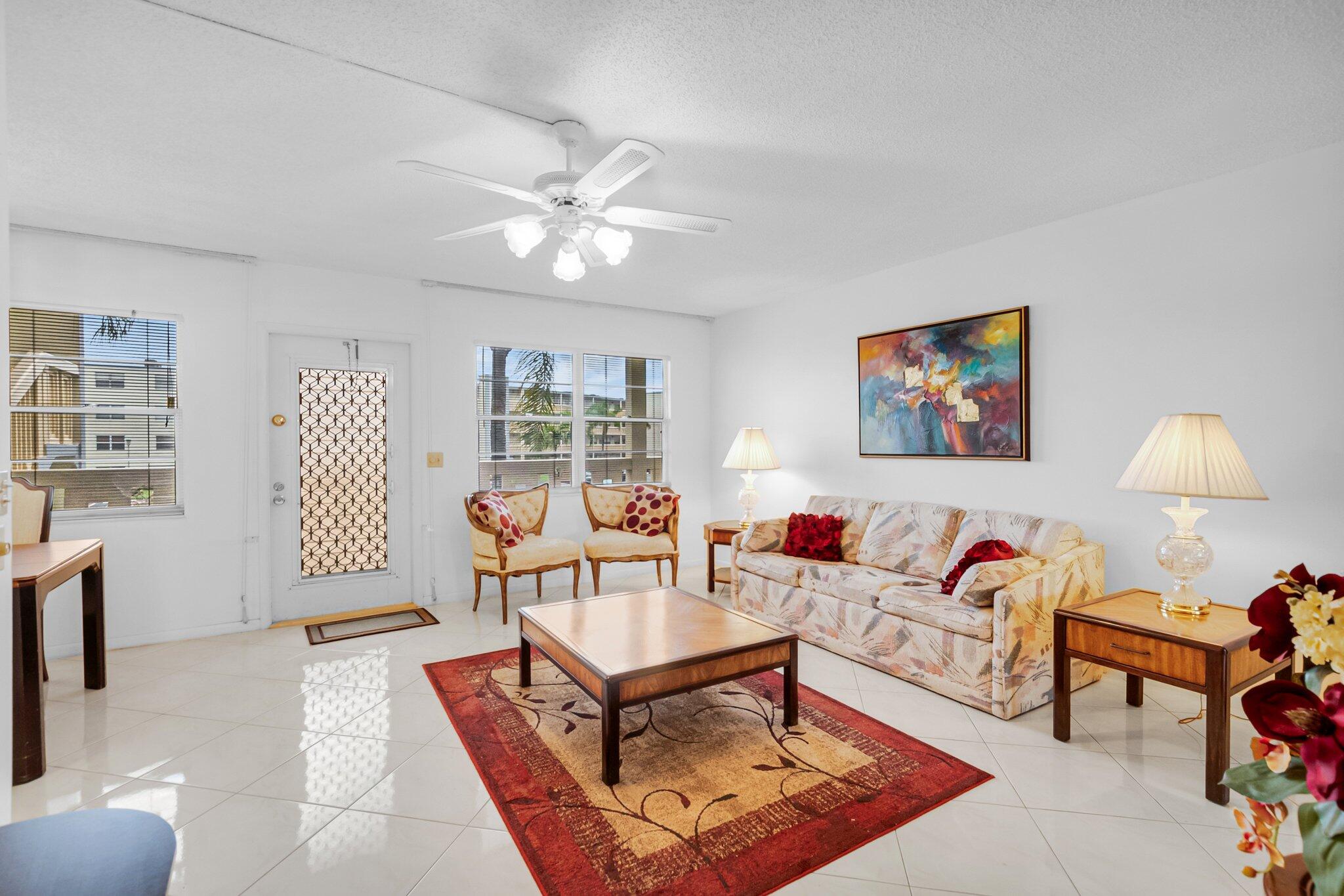 2035 Ainslie C Boca Raton, FL 33434 - Photo 2 of 17 a living room with furniture a lamp and a window