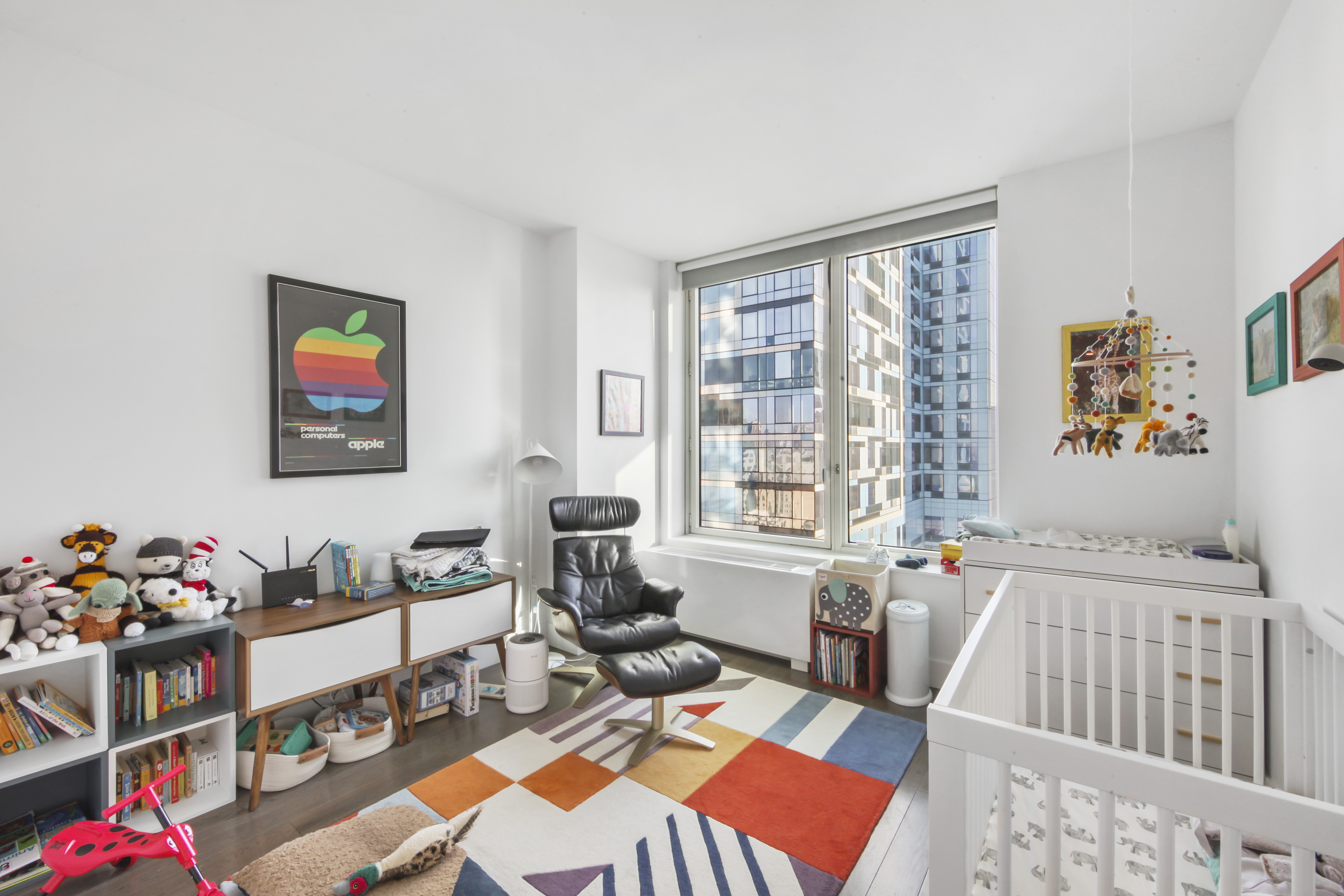 388 Bridge Street, Unit 32G Brooklyn, NY 11201 - Photo 7 of 15 a living room with furniture a baby crib and a wooden floor