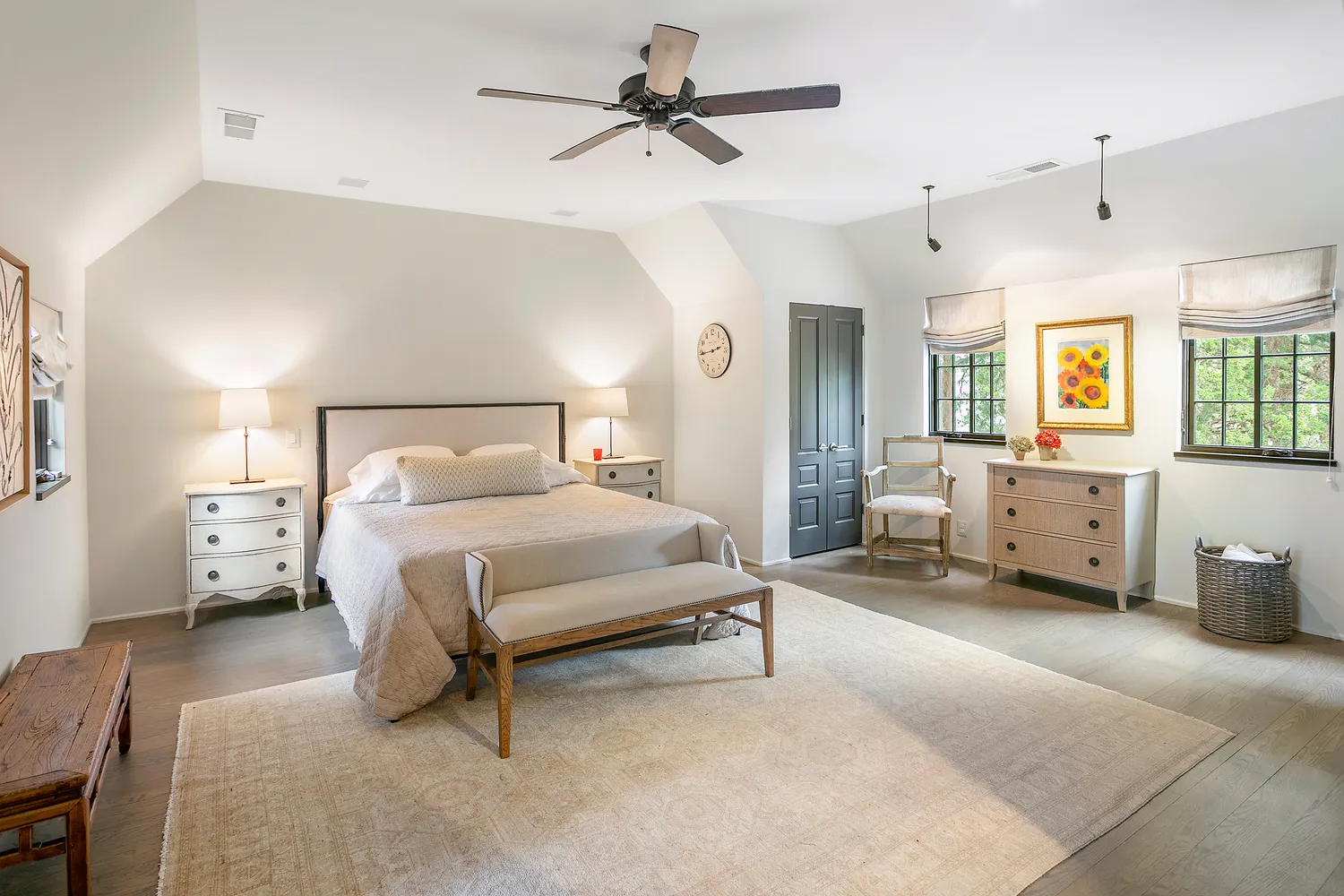a spacious bedroom with a bed a couch and a chandelier