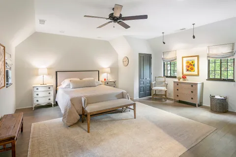 a spacious bedroom with a bed a couch and a chandelier