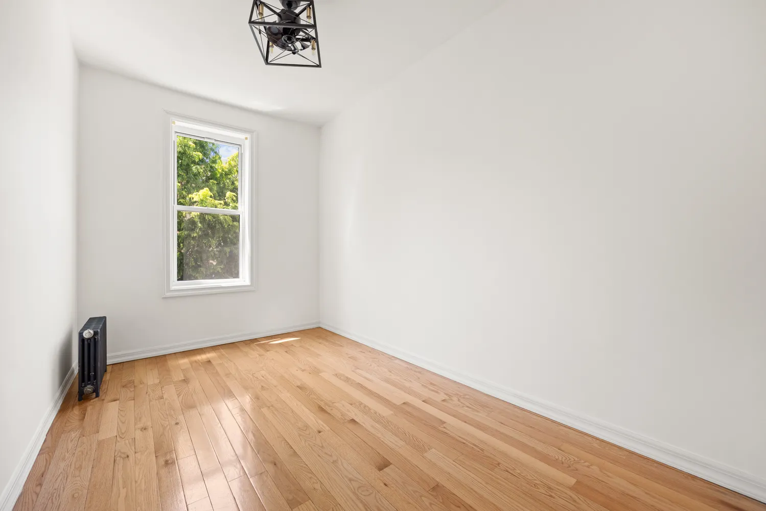 a view of a room with wooden floor and a window