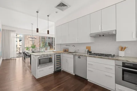a kitchen with granite countertop white cabinets and white appliances