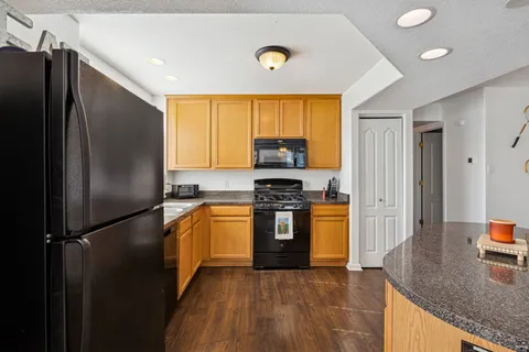 a kitchen with stainless steel appliances granite countertop a refrigerator stove and sink
