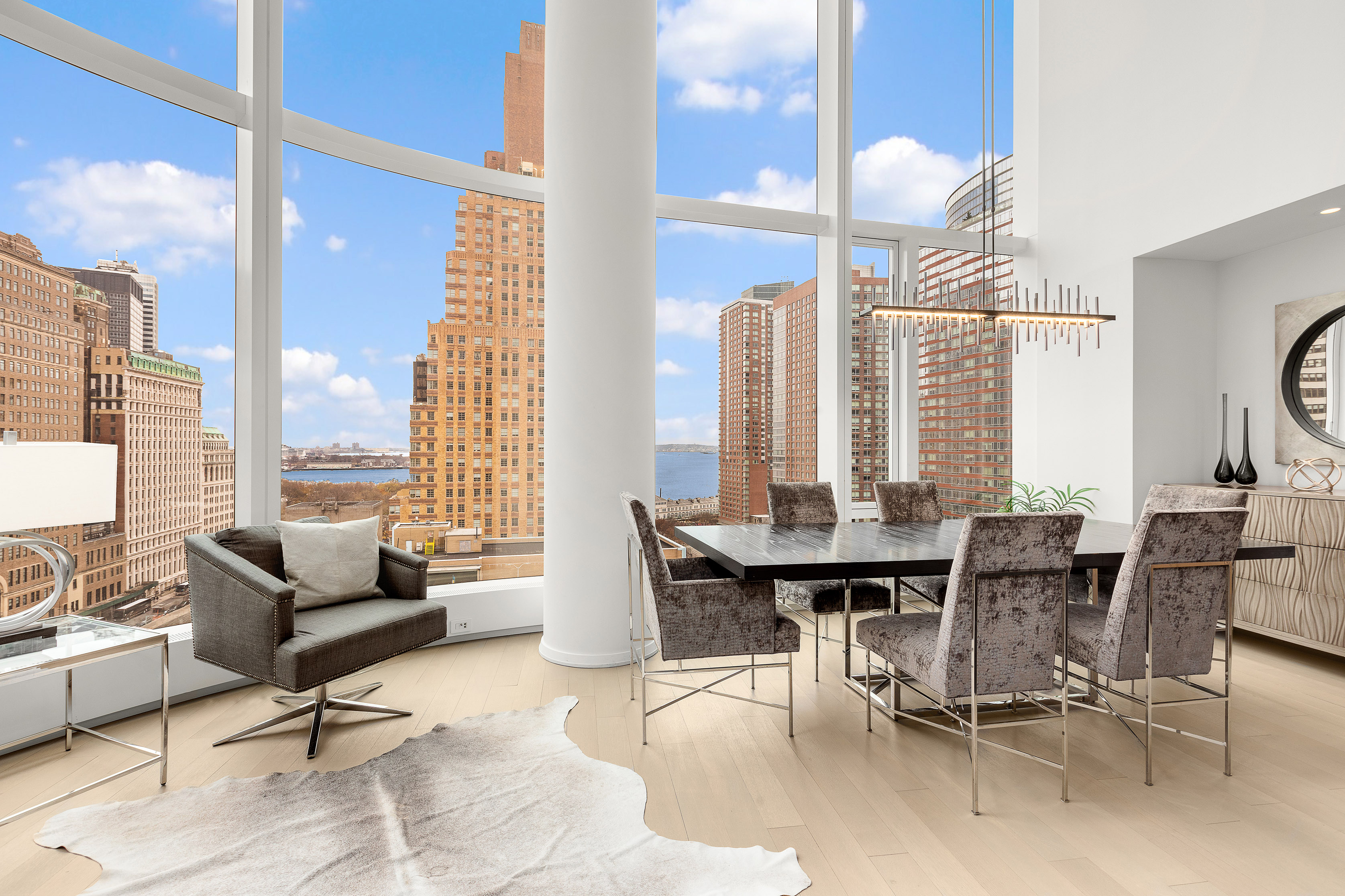 50 West Street, Unit 14B Manhattan, NY 10006 - Photo 3 of 29 a view of a dining room with furniture and floor to ceiling windows