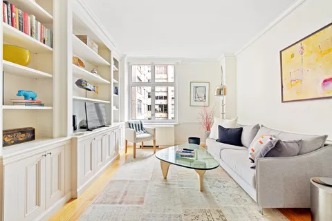 a living room with furniture a rug and a book shelf