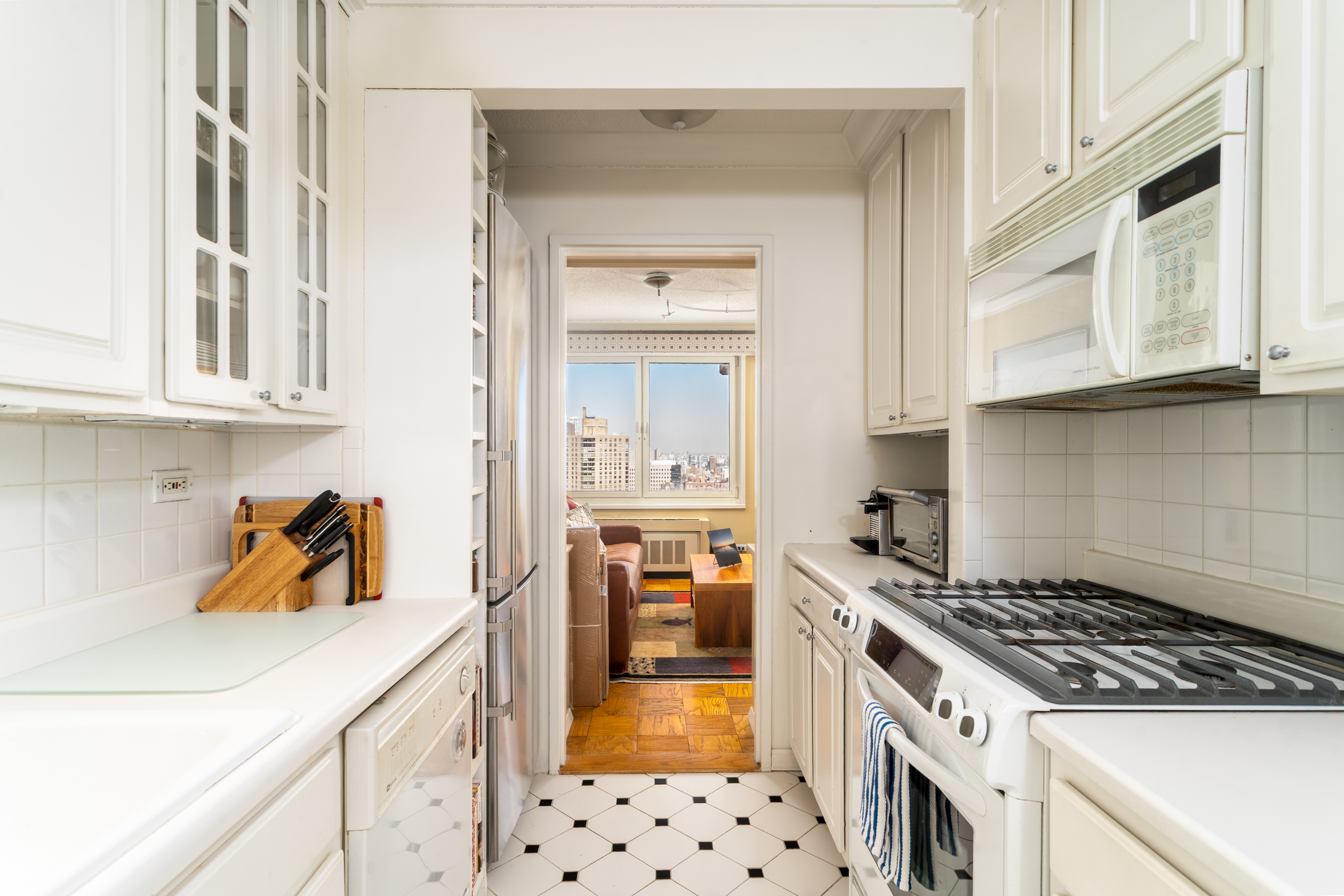 50 East 89th Street, Unit 31C Manhattan, NY 10128 - Photo 10 of 18 a kitchen with granite countertop a stove and a sink