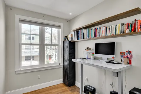 a view of a workspace with furniture bookshelf and a window