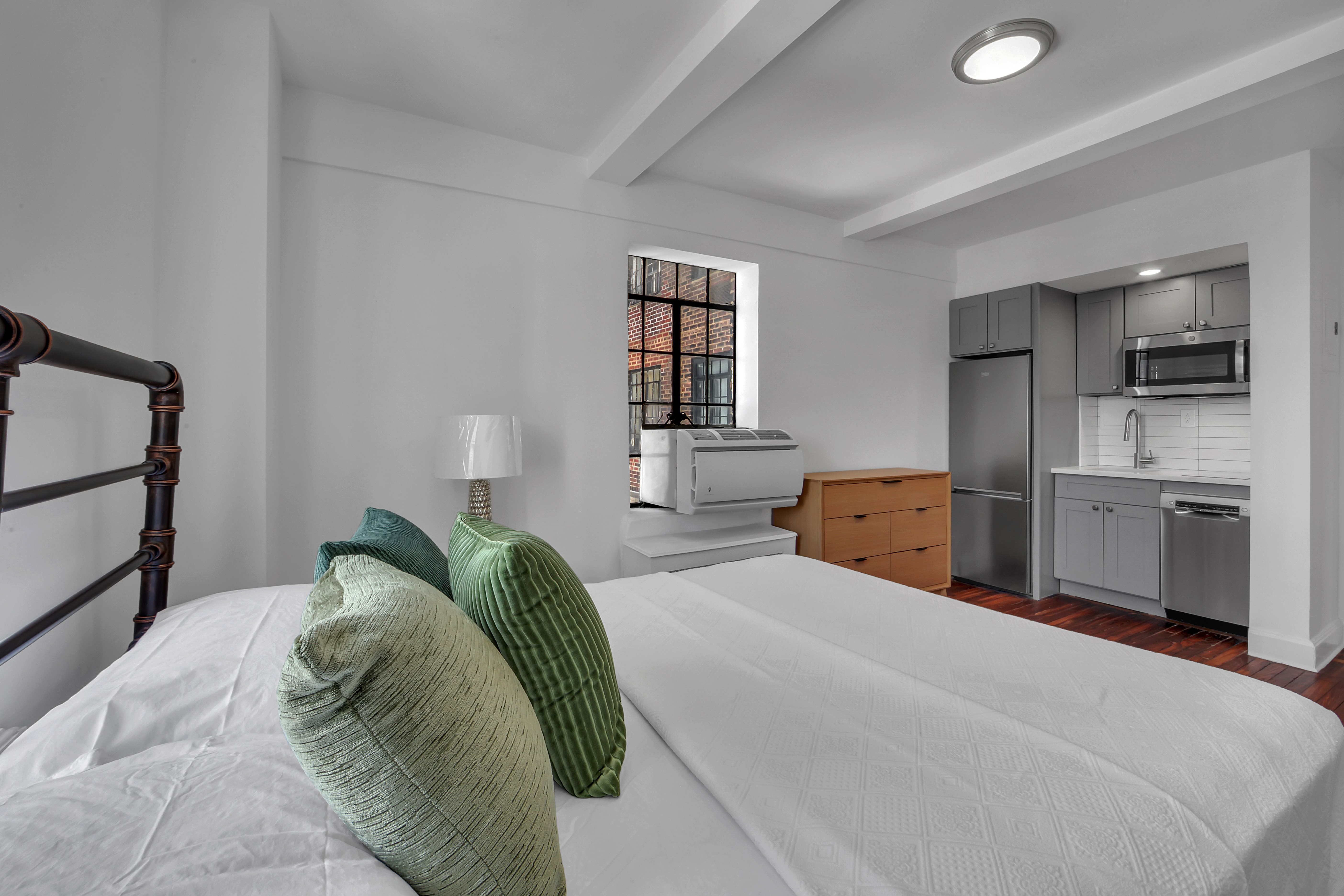 5 Tudor City Place, Unit 1536 Manhattan, NY 10017 - Photo 7 of 21 a bedroom with a bed and a large window