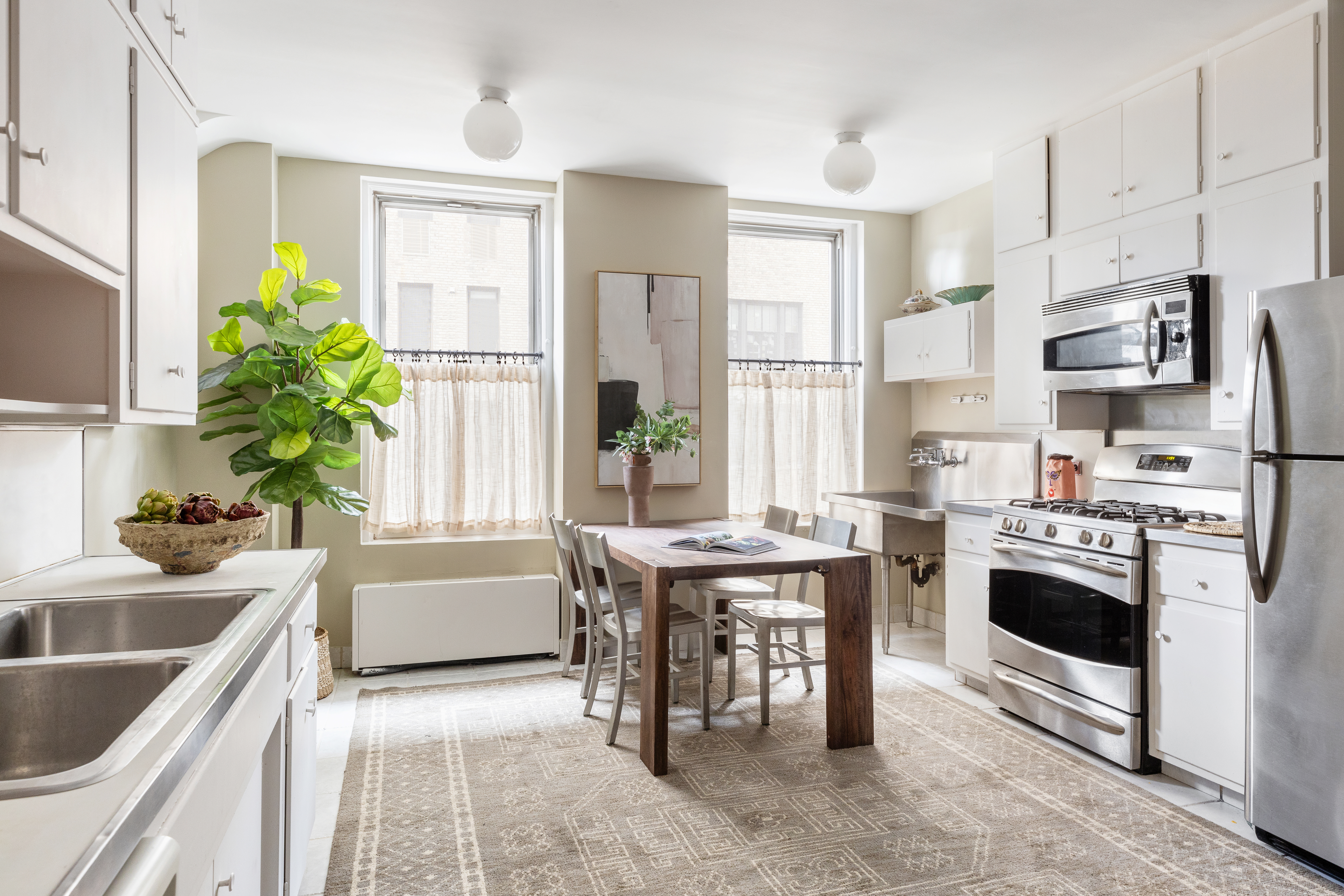 1136 5th Avenue, Unit 6A Manhattan, NY 10128 - Photo 22 of 44 a kitchen with stainless steel appliances granite countertop a sink a stove and a refrigerator