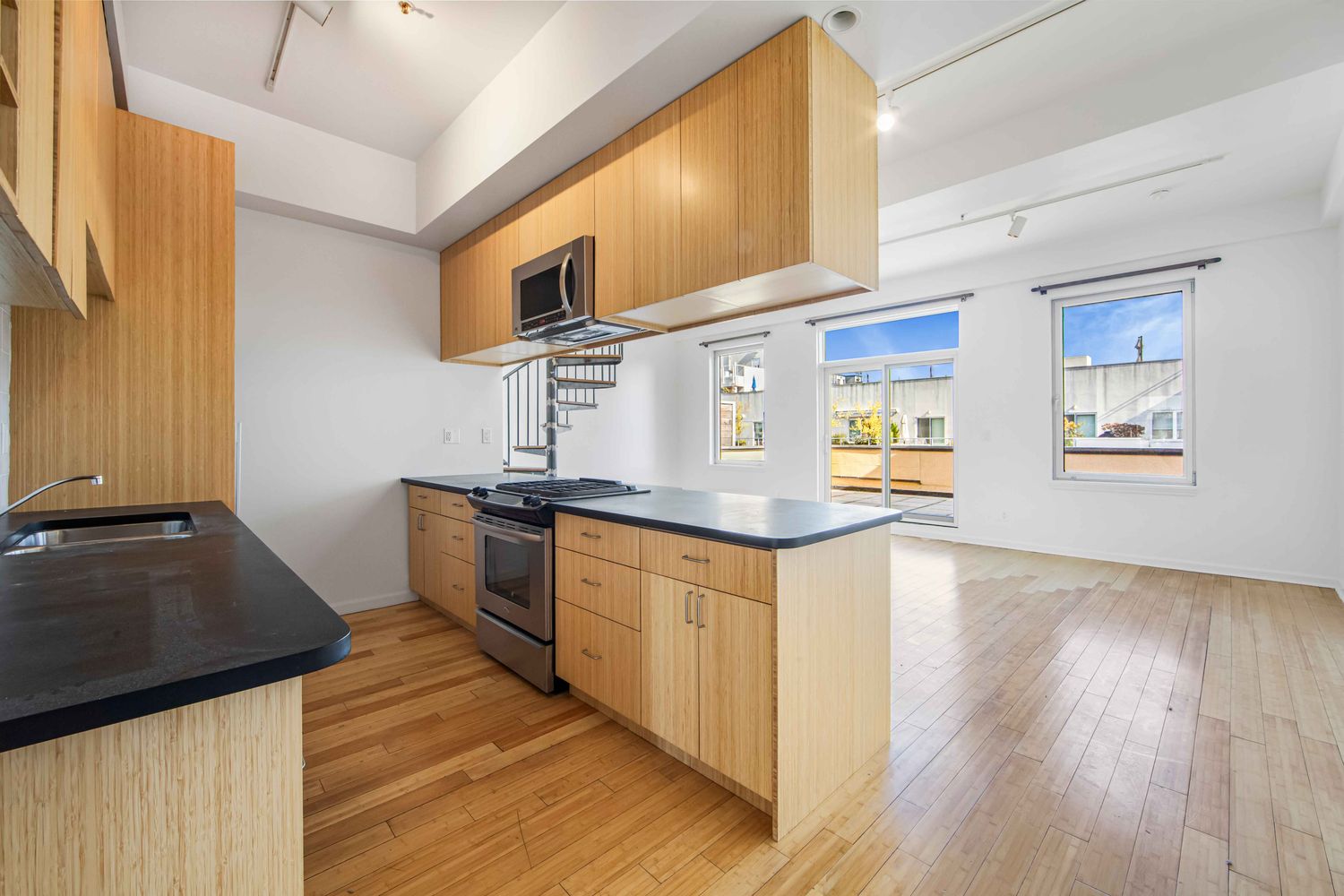 a kitchen with stainless steel appliances granite countertop a sink stove and wooden floor