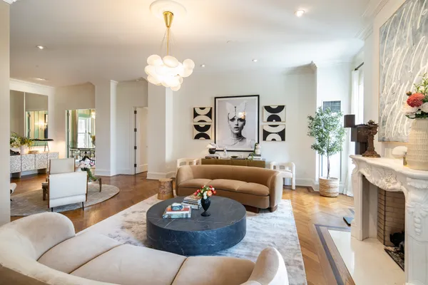 a living room with furniture a fireplace and a chandelier