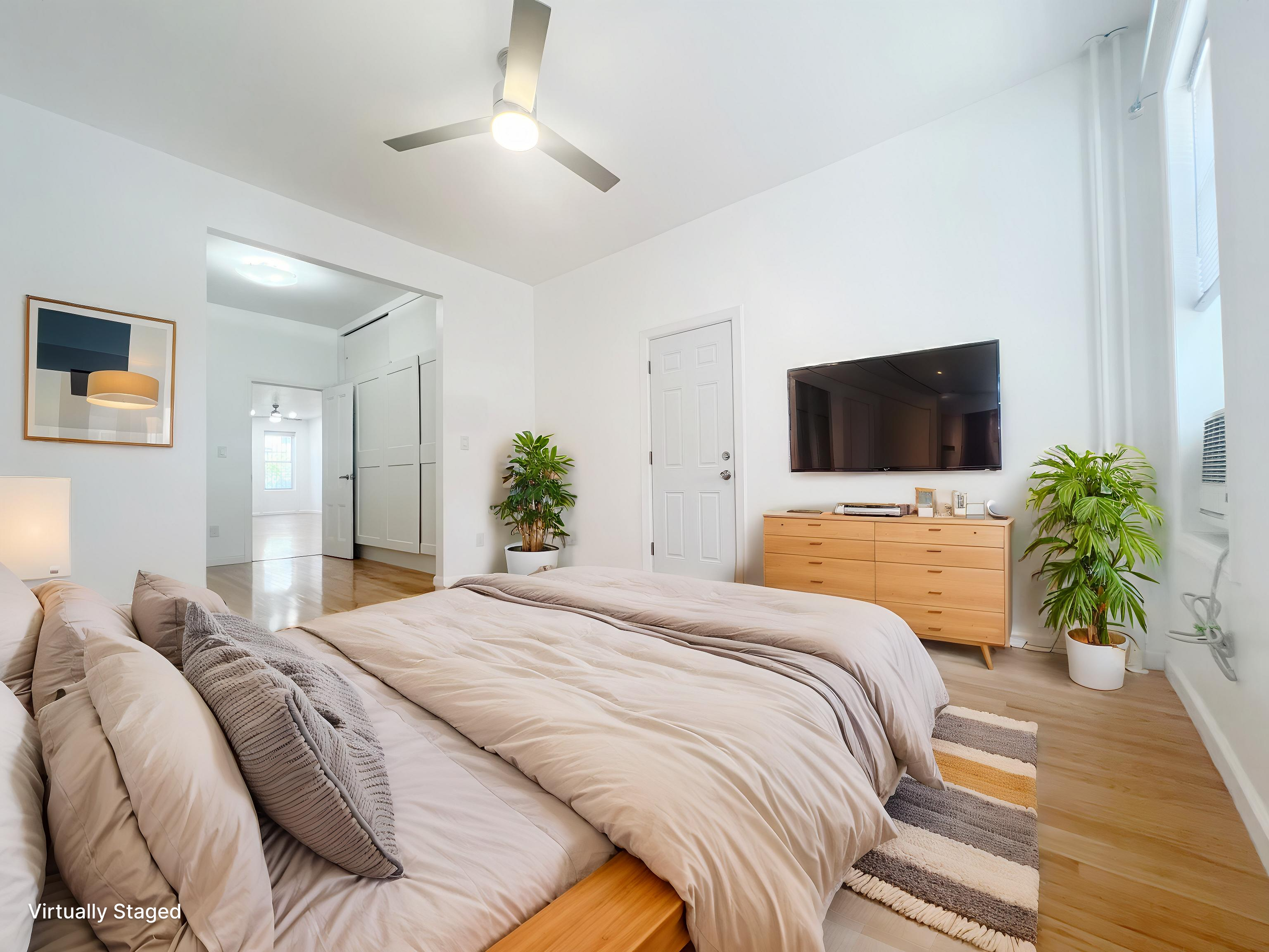 17-22 Menahan Street, Unit 1 Queens, NY 11385 - Photo 3 of 9 a bedroom with a bed and a flat tv screen on dresser