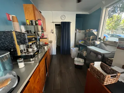 a kitchen with stainless steel appliances granite countertop a refrigerator a stove and a dining table with wooden floor