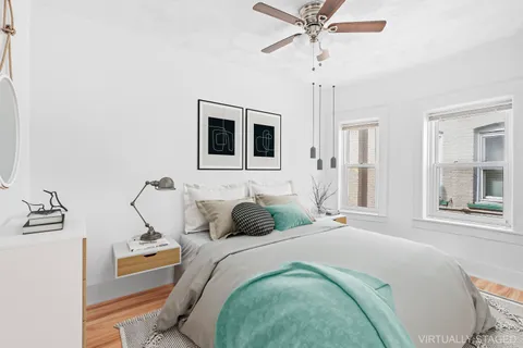 a bedroom with a large bed and a chandelier