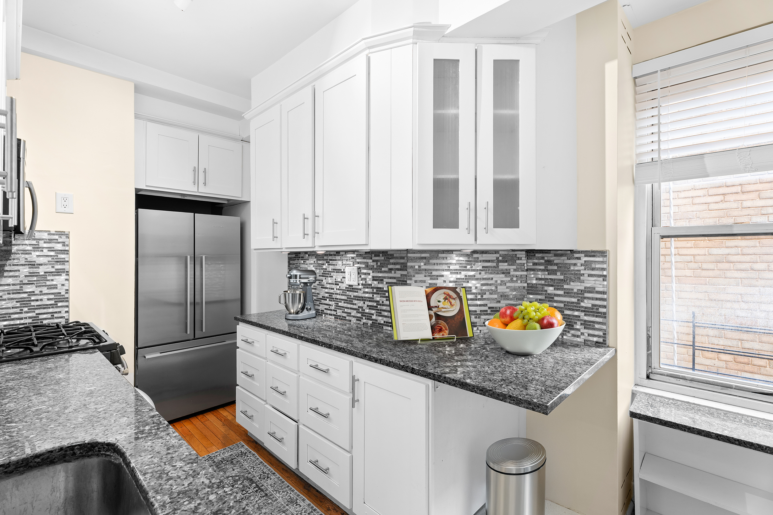 1435 Lexington Avenue, Unit 10C Manhattan, NY 10128 - Photo 3 of 12 a kitchen with stainless steel appliances granite countertop a refrigerator and a stove