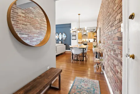 a view of a hallway with wooden floor and a mirror