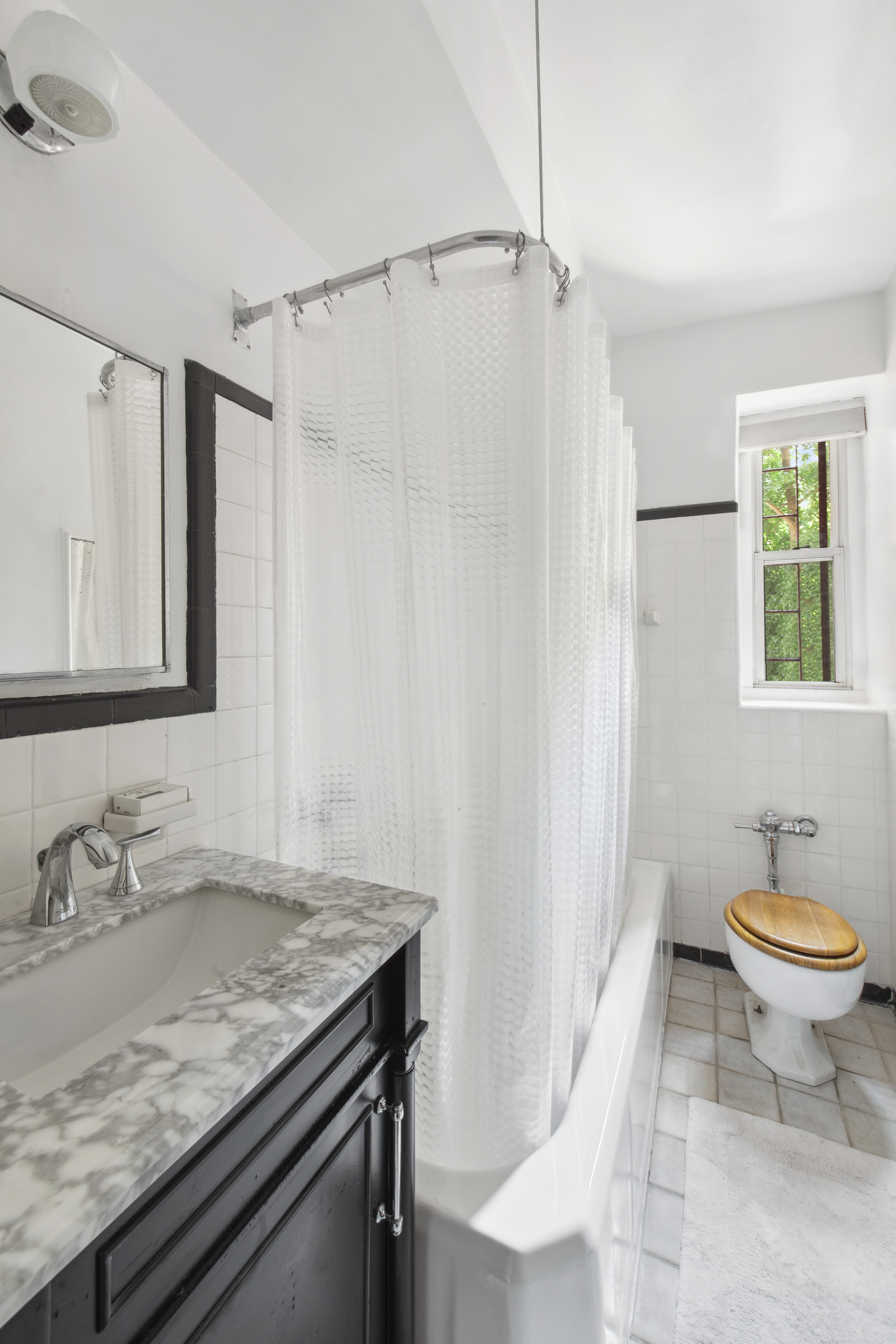 515 East 89th Street, Unit 2E Manhattan, NY 10128 - Photo 7 of 17 a bathroom with a granite countertop sink a toilet a mirror and shower