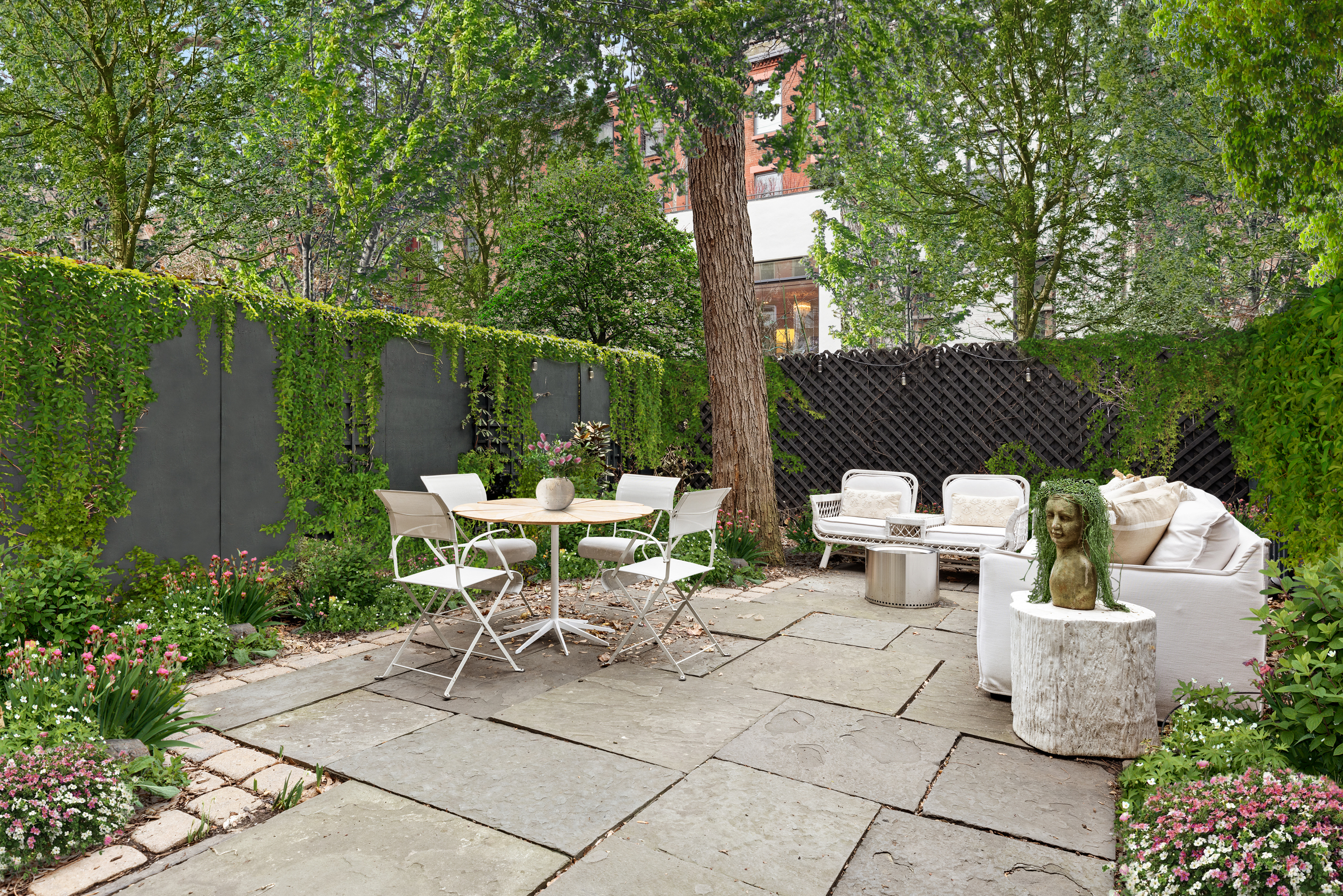 72 Perry Street, Unit GARDEN Manhattan, NY 10014 - Photo 11 of 15 a view of a patio with a table and chairs and potted plants