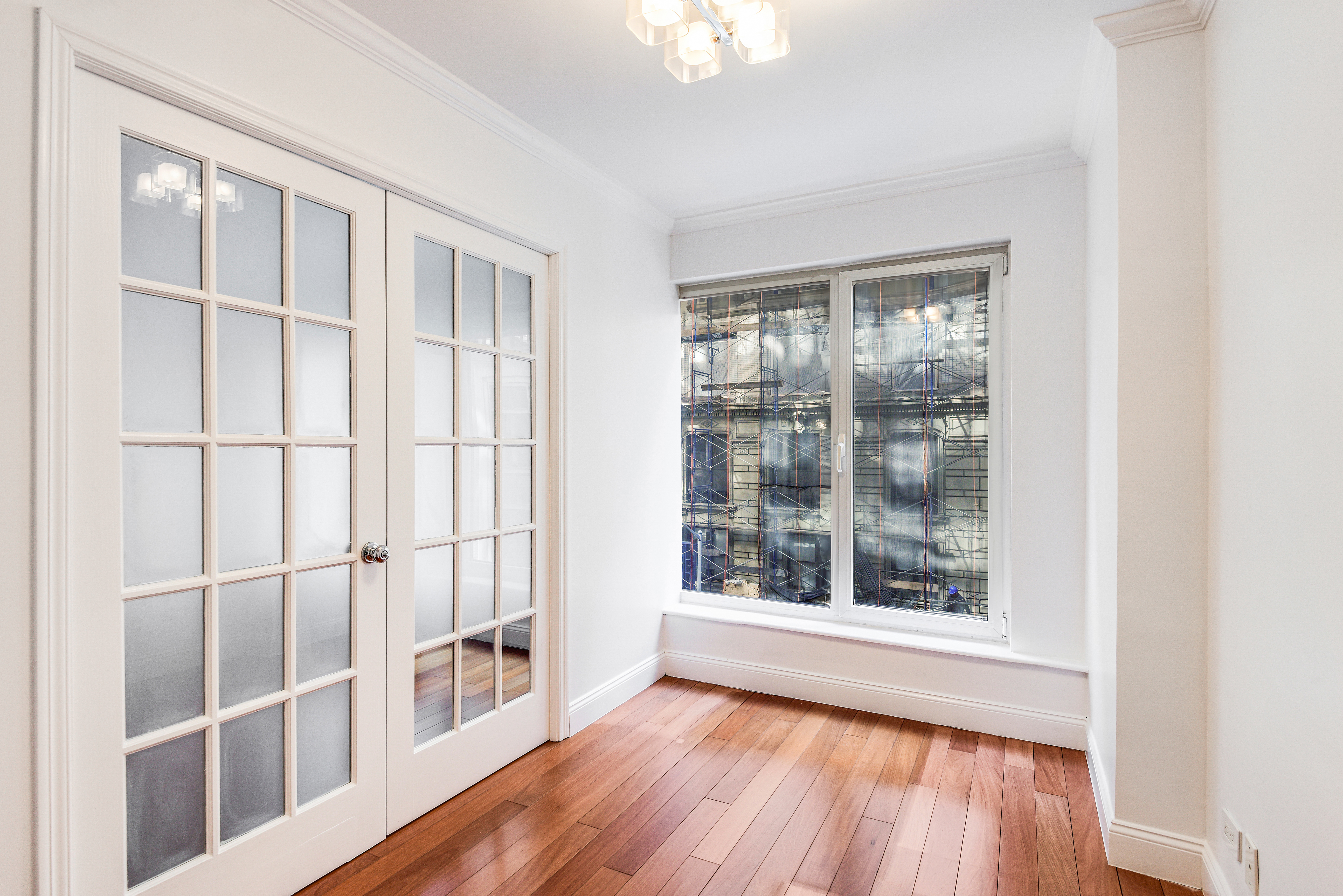 200 Central Park South, Unit 5M Manhattan, NY 10019 - Photo 13 of 15 an empty room with wooden floor and windows