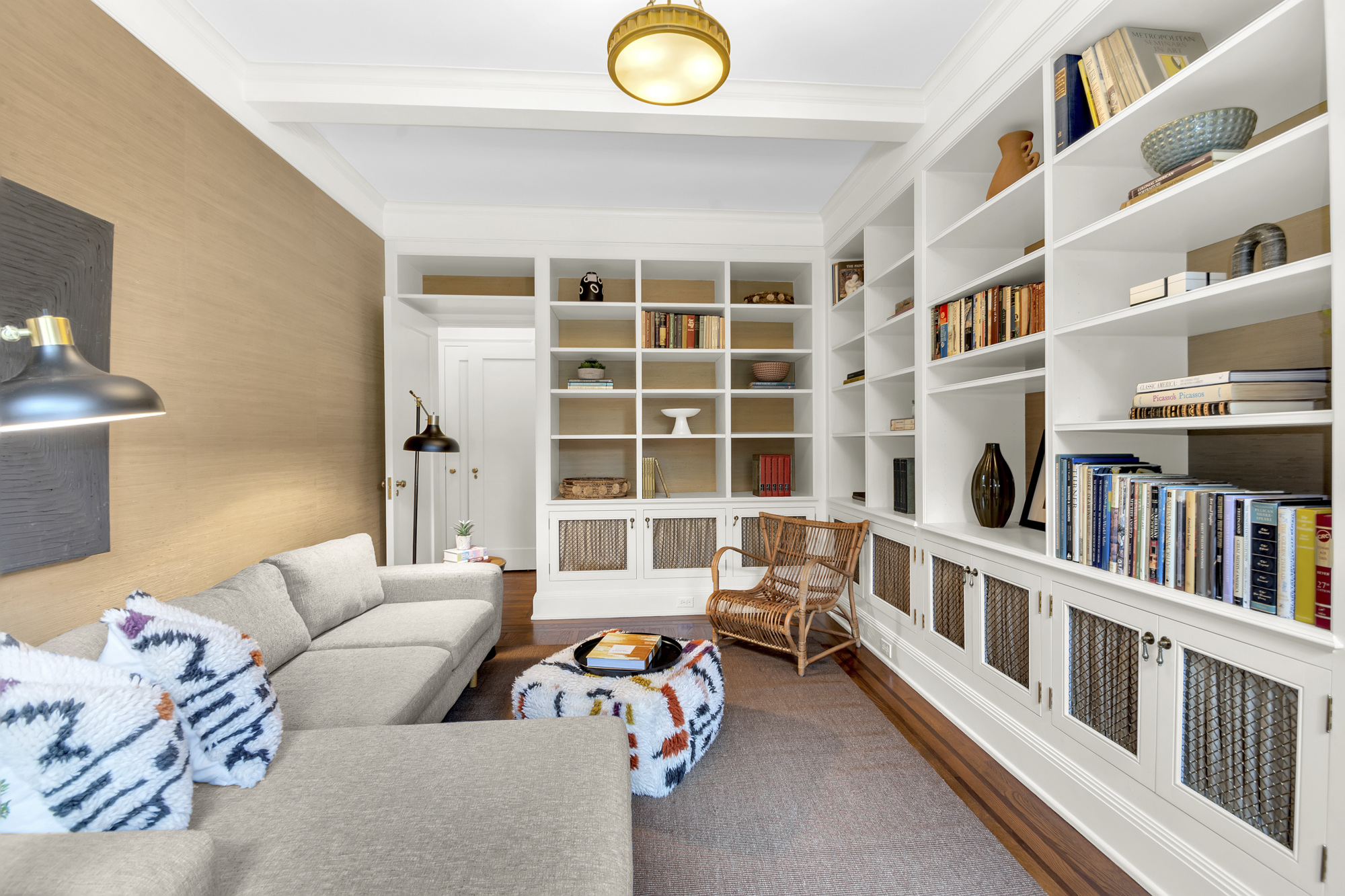 7 Gracie Square, Unit 5A Manhattan, NY 10128 - Photo 6 of 26 a living room with furniture and a book shelf
