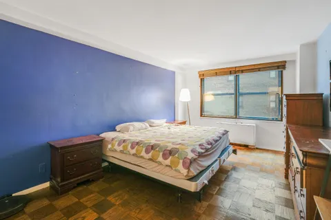 a bed sitting in a bedroom next to a window