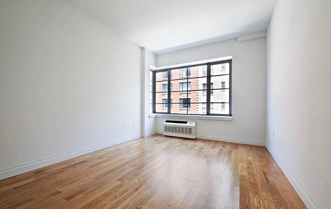 58 West 129th Street, Unit 5A Manhattan, NY 10027 - Photo 5 of 7 wooden floor in an empty room with a window