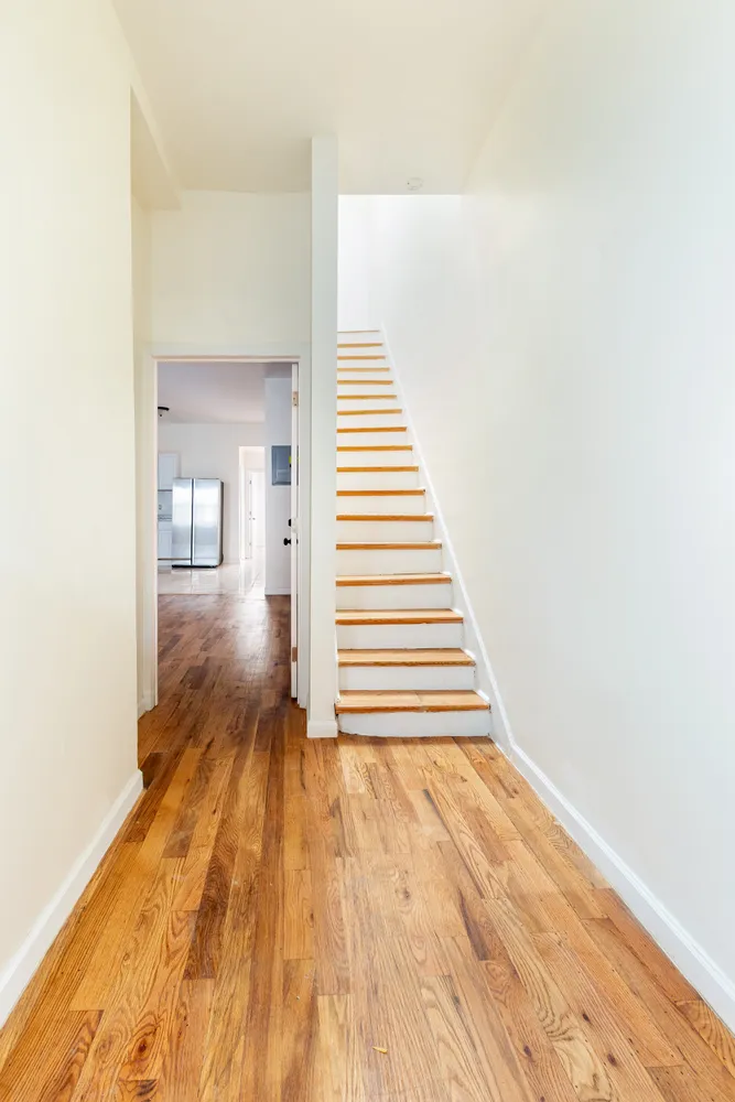 a view of a hallway with wooden floor and staircase