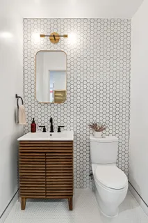 a bathroom with a toilet sink and mirror