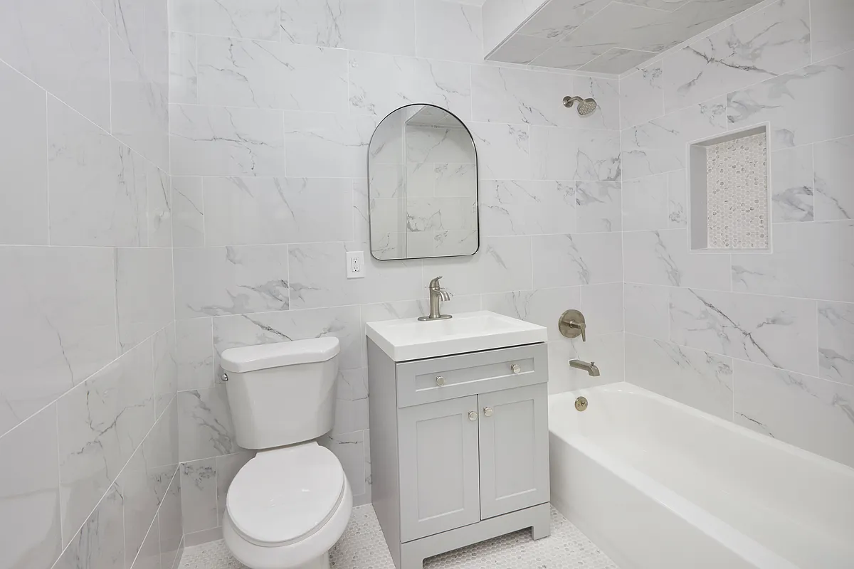 10220 Rockaway Beach Boulevard, Unit 1A Queens, NY 11694 - Photo 6 of 8 a bathroom with a toilet sink and bathtub