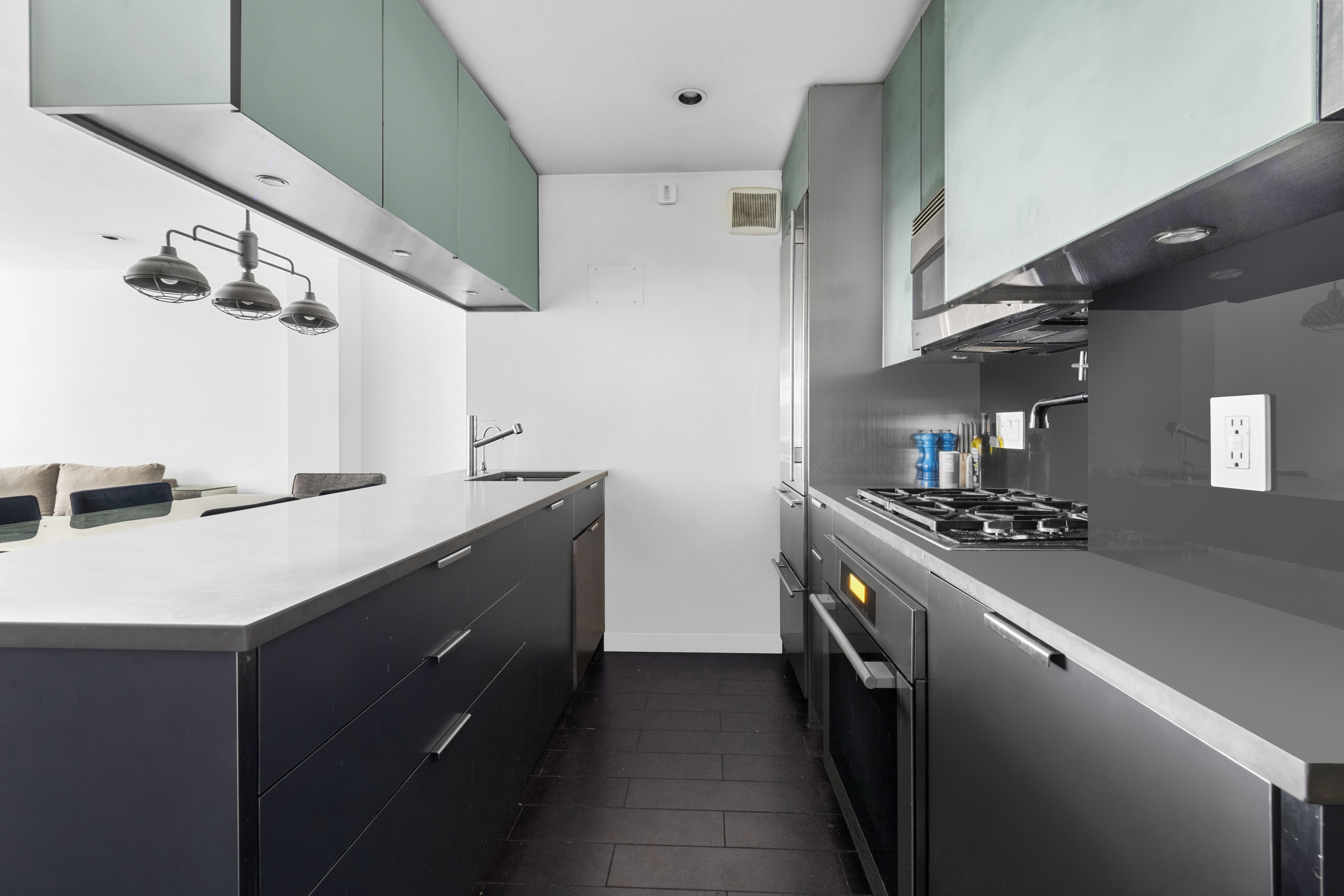 235 East 57th Street, Unit 5D Manhattan, NY 10022 - Photo 4 of 10 a kitchen with stainless steel appliances a sink and stove