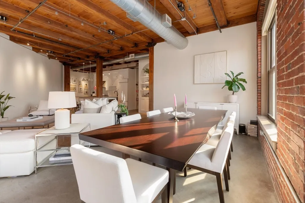 a dining room with furniture and a potted plant