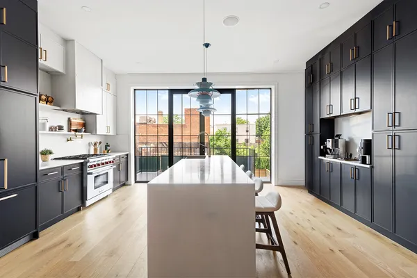 a large kitchen with a large window and stainless steel appliances