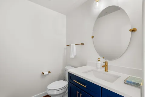 a bathroom with a toilet a sink and mirror