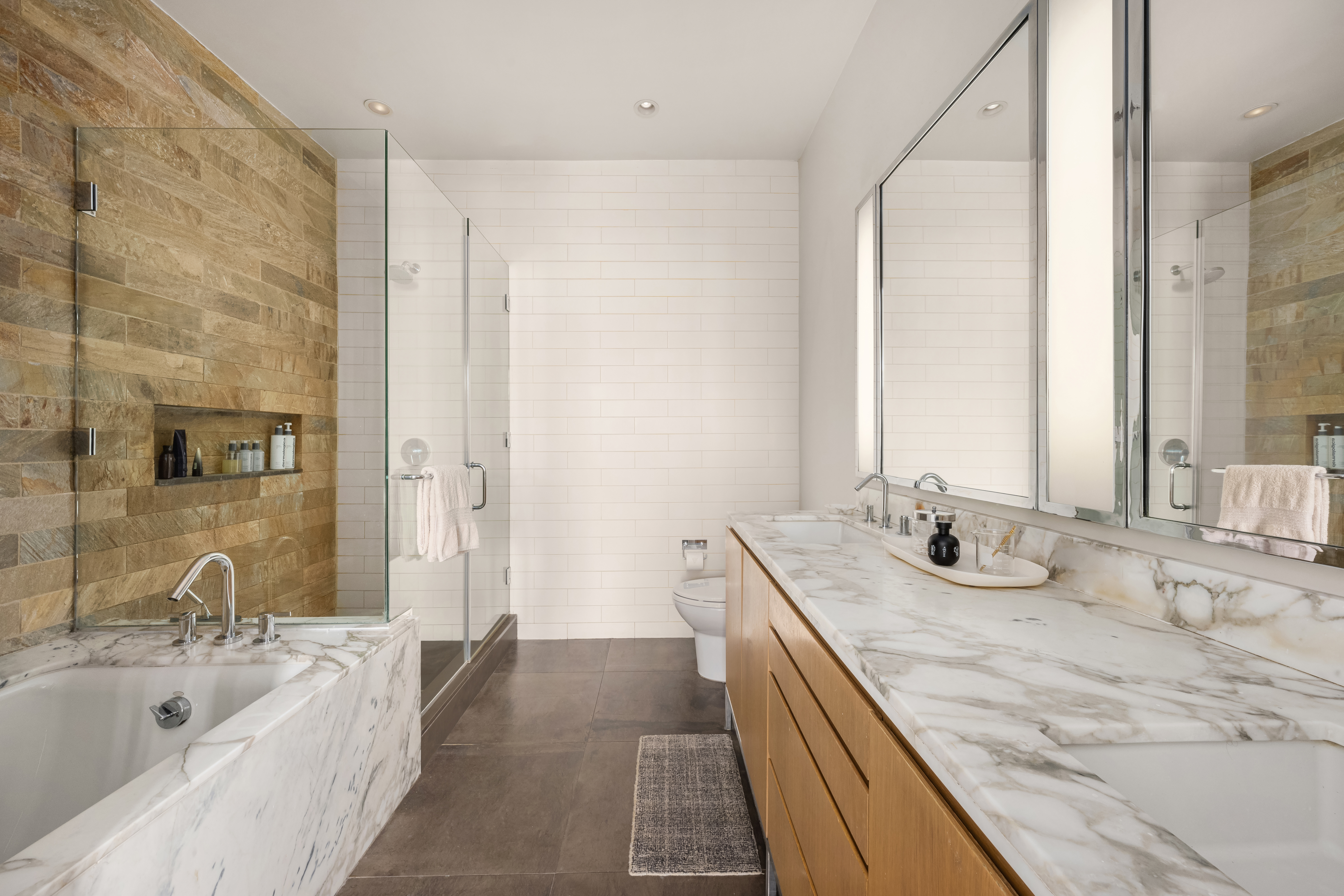 263 9th Avenue, Unit 7E Manhattan, NY 10001 - Photo 10 of 17 a bathroom with a granite countertop tub sink and mirror