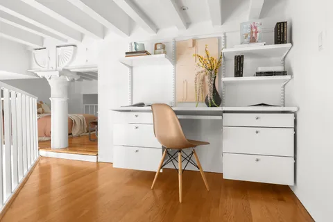 a view of a workspace with furniture and wooden floor