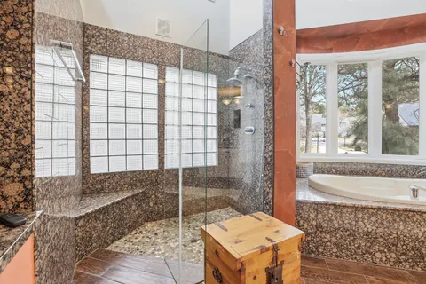 a spacious bathroom with a granite countertop tub sink and mirror