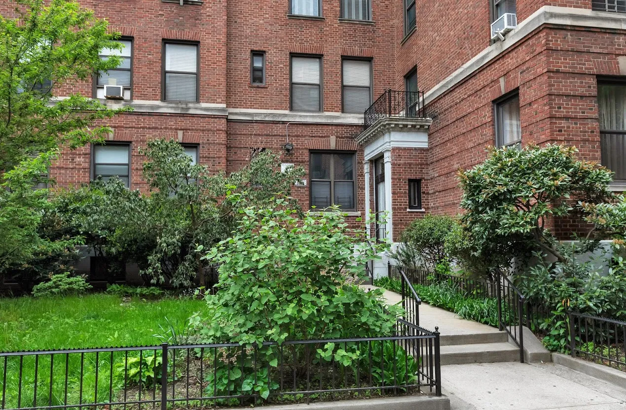 a view of a brick building next to a yard