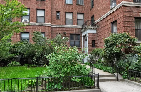 a view of a brick building next to a yard