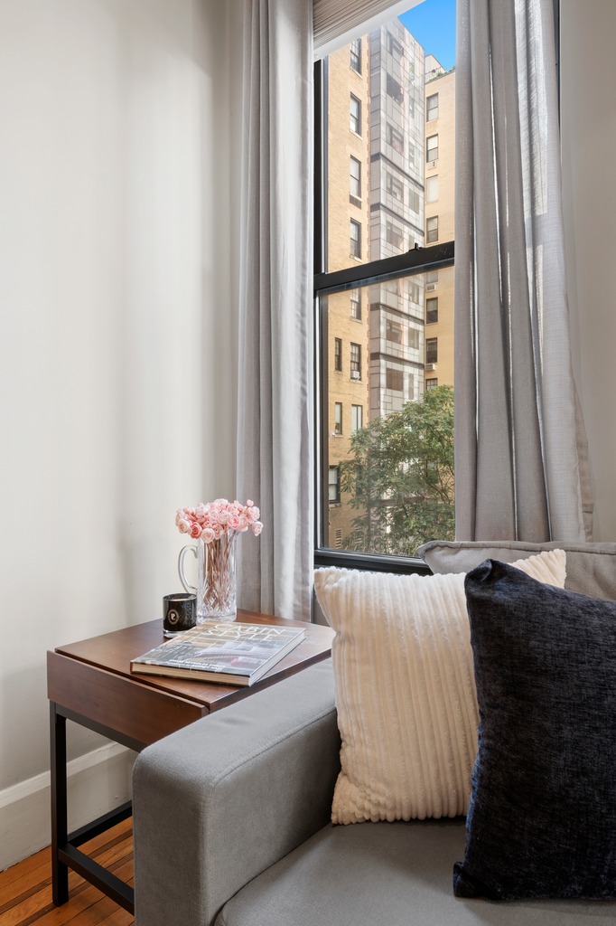 444 East 58th Street, Unit 6C Manhattan, NY 10022 - Photo 7 of 9 a living room with a couch and a window