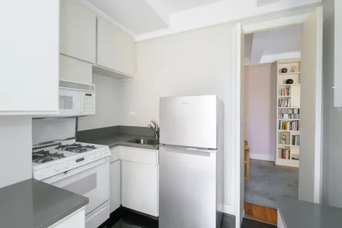 a kitchen with a stove a refrigerator and a cabinets