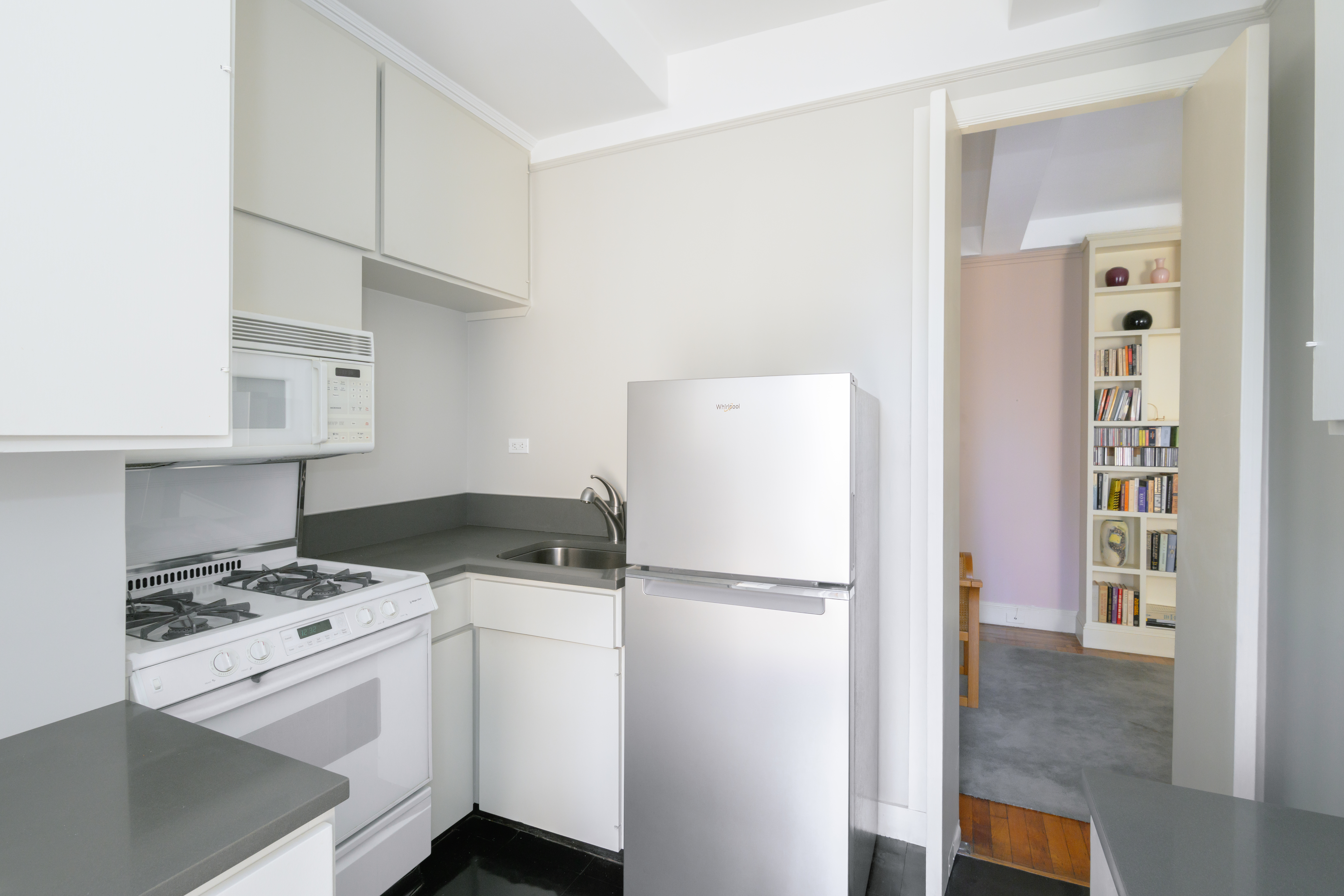 2 West 67th Street, Unit 14/15E Manhattan, NY 10023 - Photo 8 of 10 a kitchen with a stove a refrigerator and a cabinets