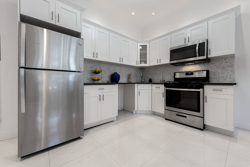 16 Pilling Street Brooklyn, NY 11207 - Photo 4 of 11 a kitchen with stainless steel appliances granite countertop a refrigerator stove a sink and dishwasher with white cabinets