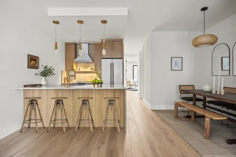 a living room with table chairs and a wooden floor