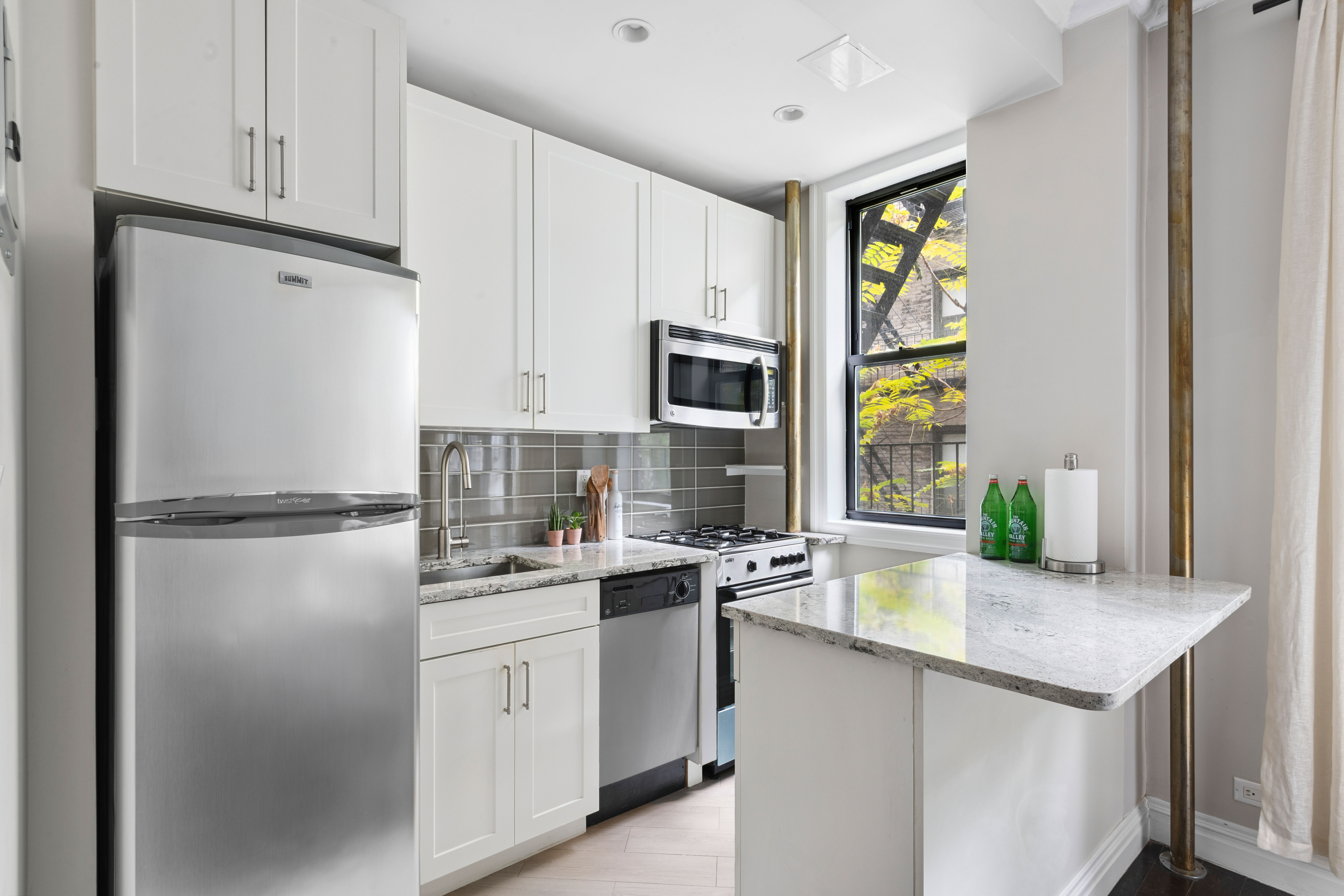 17 West 64th Street, Unit 4E Manhattan, NY 10023 - Photo 1 of 9 a kitchen with a sink a stove and refrigerator