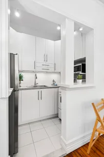 a kitchen with white cabinets and refrigerator